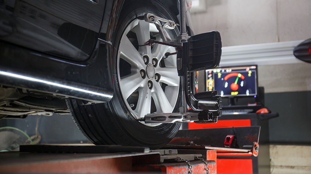 Car on stand with sensors on wheels for wheels alignment check in workshop of Service station.